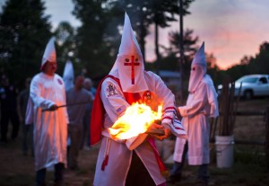 Members of the Rebel Brigade Knights of the Ku Klux Klan light their torches during a cross lighting ceremony on private property near Martinsville, Virginia, USA, 02 July 2011. (EPA/JIM LO SCALZO)